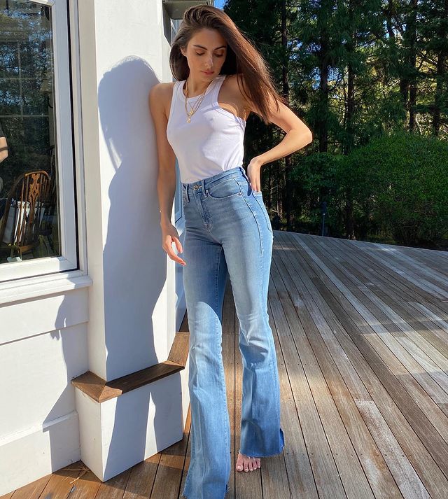 Paige DeSorbo in a white sleeveless and blue jeans.